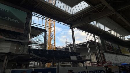 Ein gelber Turmdrehkran steht auf der Baustelle.