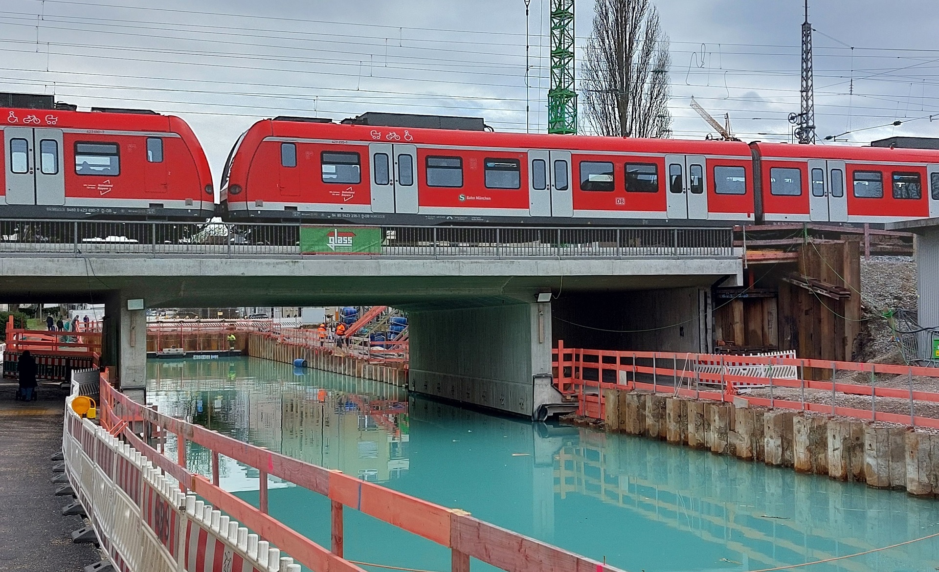 Die Baustelle der Bahnbrücke an der Dachauer Straße mit gefluteter Baugrube unter der Brücke