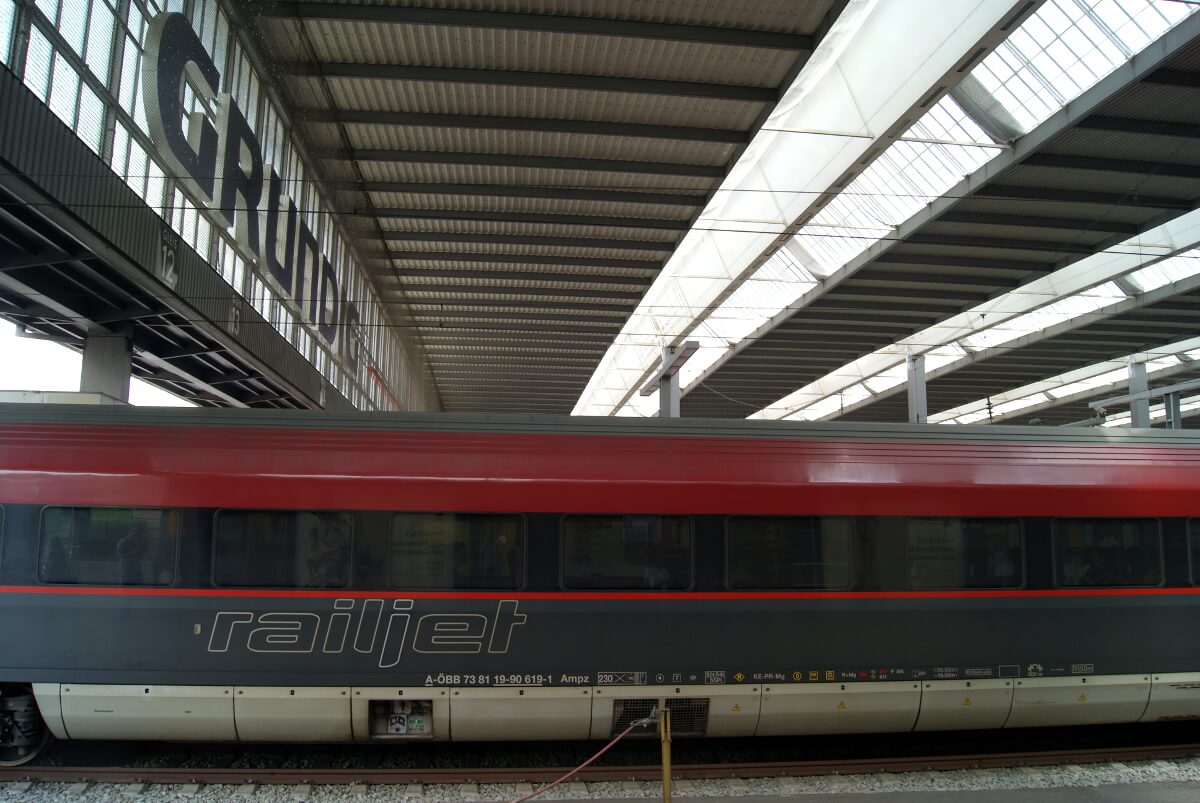 Das Dach der Halle und ein railjet Zug im Vordergrung.