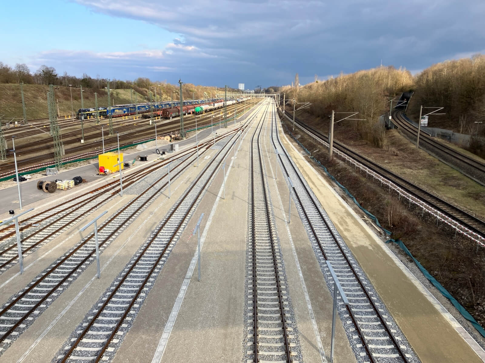 Mehrere neu gebaute Bahngleise. Links und rechts davon ältere Gleise.