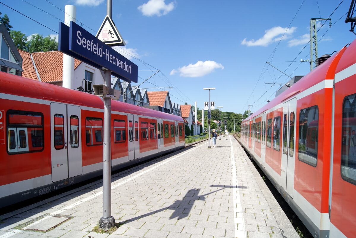 Der Außenbahnsteig Seefeld-Hechendorf. An beiden Bahnsteigen stehen S-Bahnen. Im Hintergrund sind Häuser.