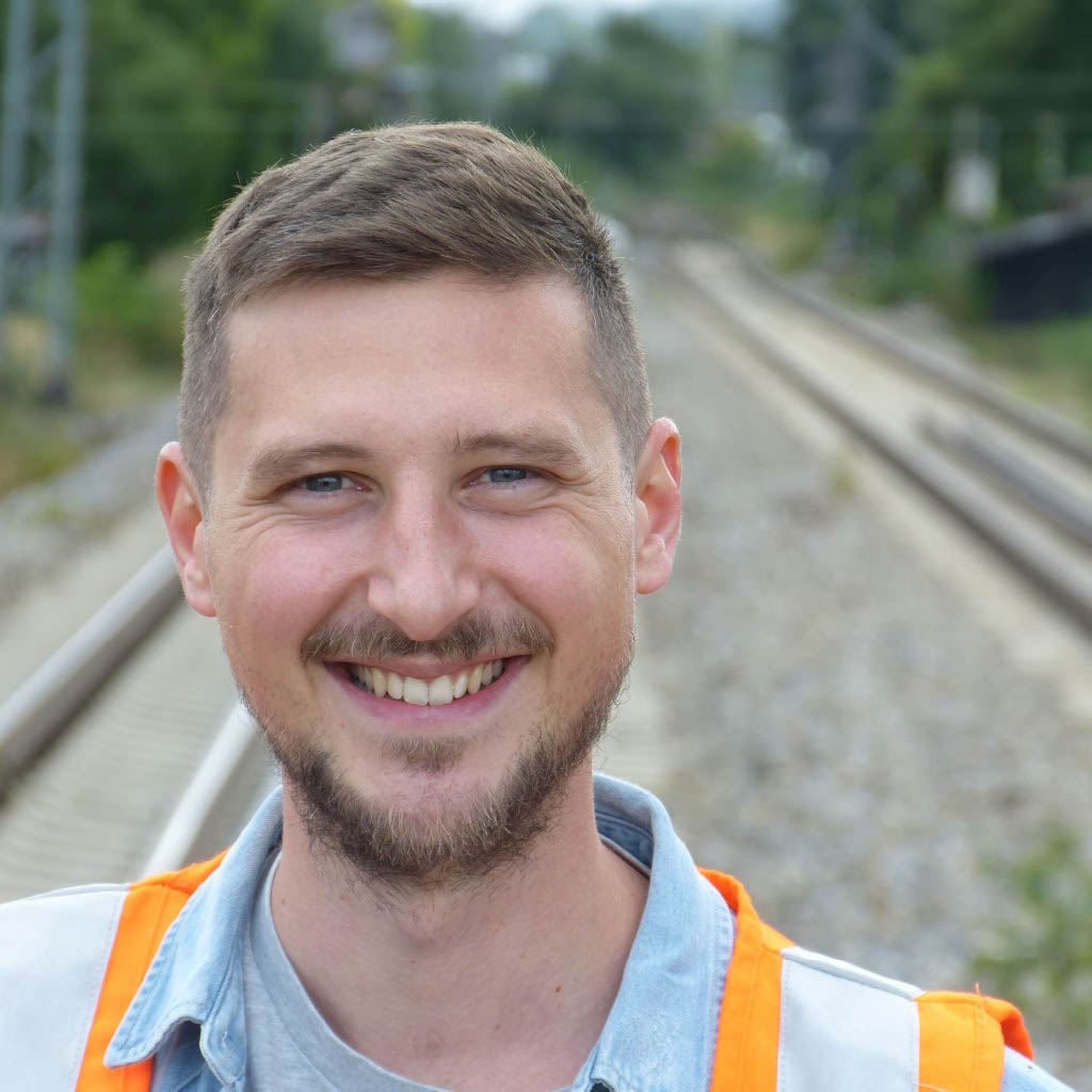 Porträtfoto Lorenz Stein mit Sicherheitsweste an einer Eisenbahnstrecke