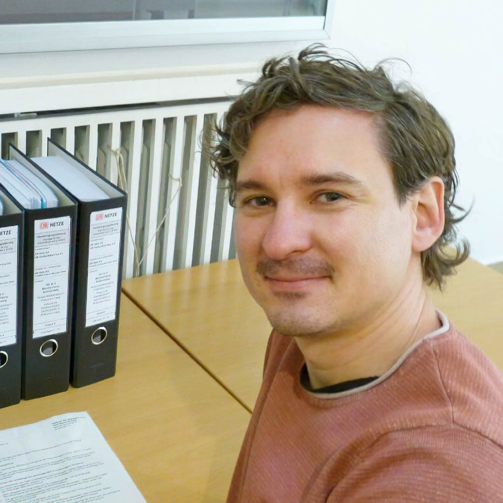 Philipp Müller an einem Schreibtisch mit Ordnern