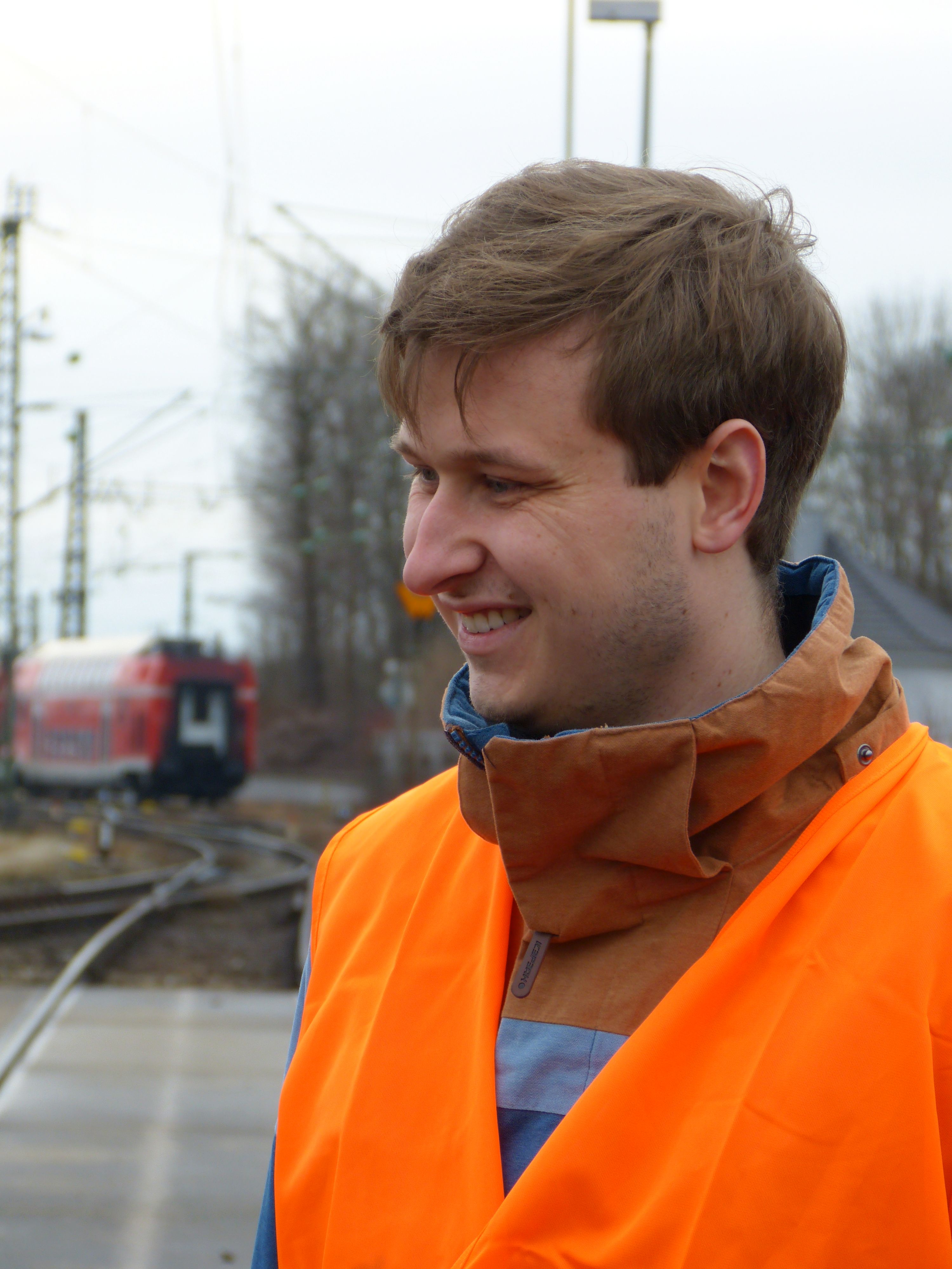 Foto eines lachenden Mitarbeiters in Schutzkleidung.