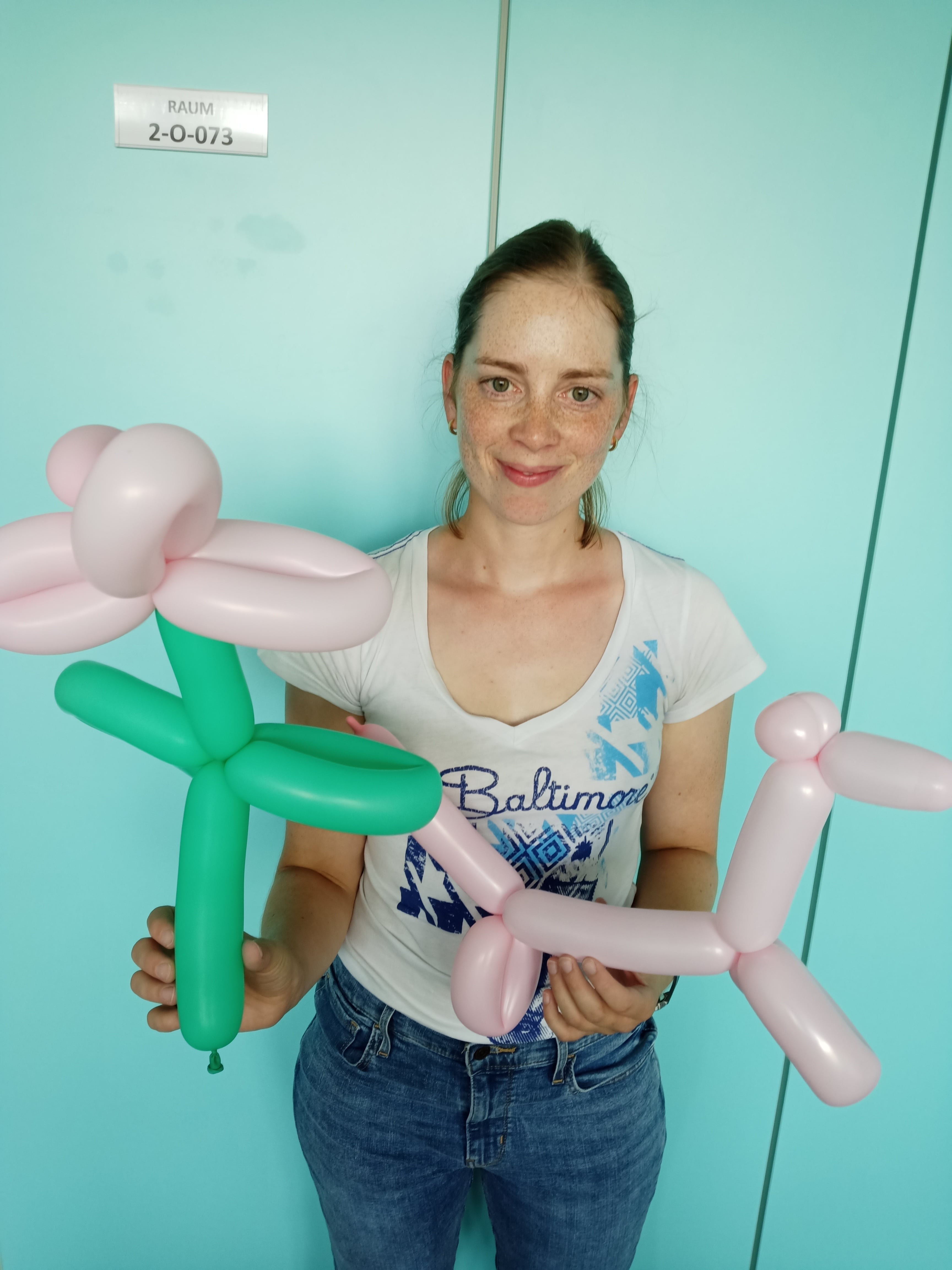 Eine Mitarbeiterin hat zwei Ballon-Tiere in den Händen.
